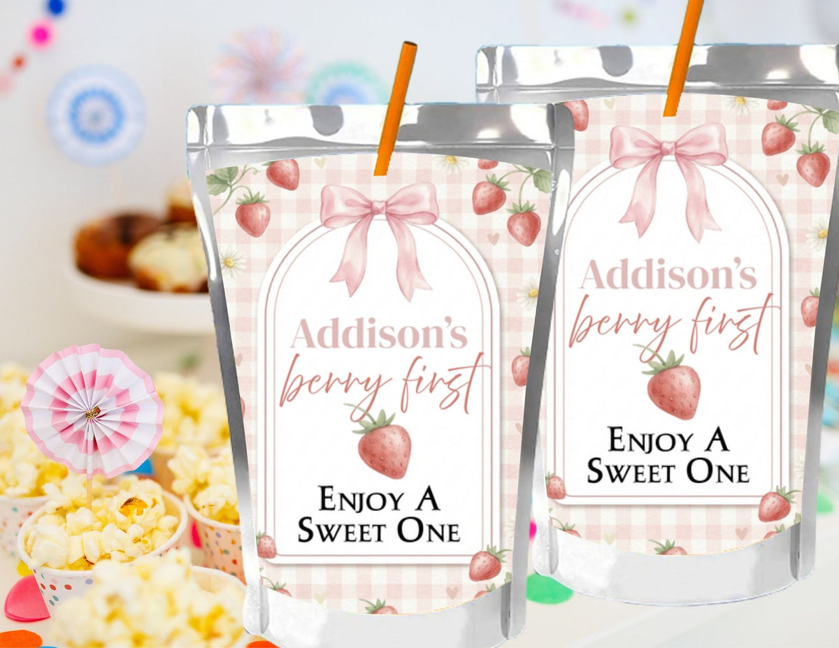 Two silver cups with pink strawberry-themed labels on a colorful background.