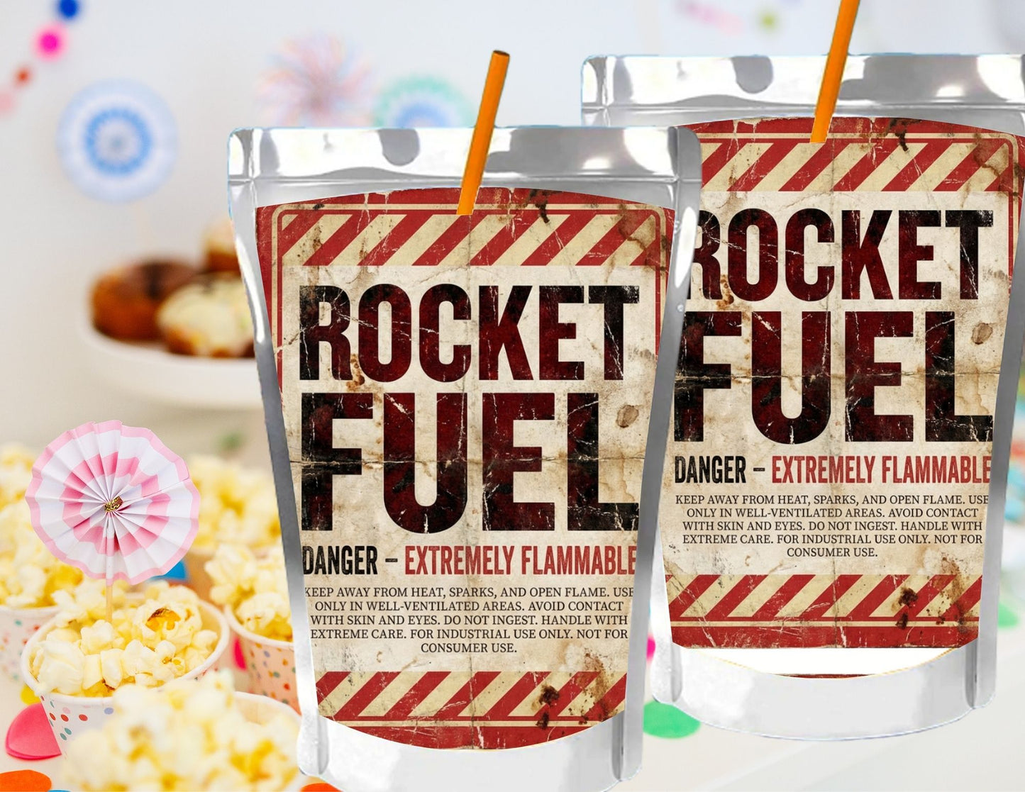Two 'Rocket Fuel' drinks with straws on a colorful background with popcorn and snacks.