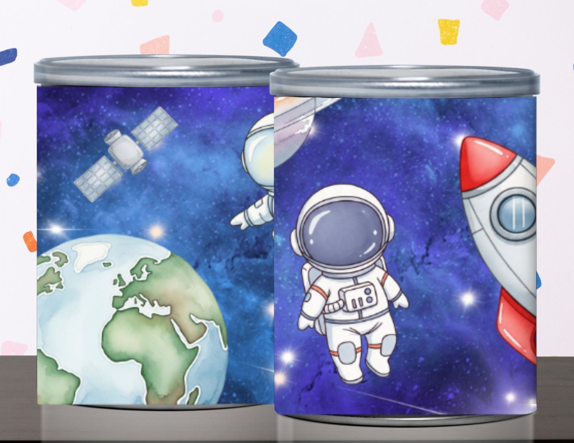 Two cylindrical containers with space-themed designs featuring an astronaut, Earth, and a rocket.