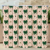 Three cylindrical containers with a green bow pattern on a beige background, placed on a wooden surface with plants in the background.