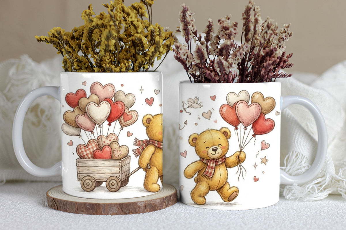Two mugs with teddy bear designs and heart balloons on a white surface.