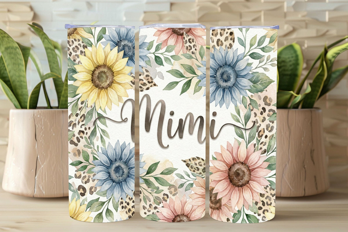 Three floral tumblers with 'Mimi' text on a wooden surface with plants in the background