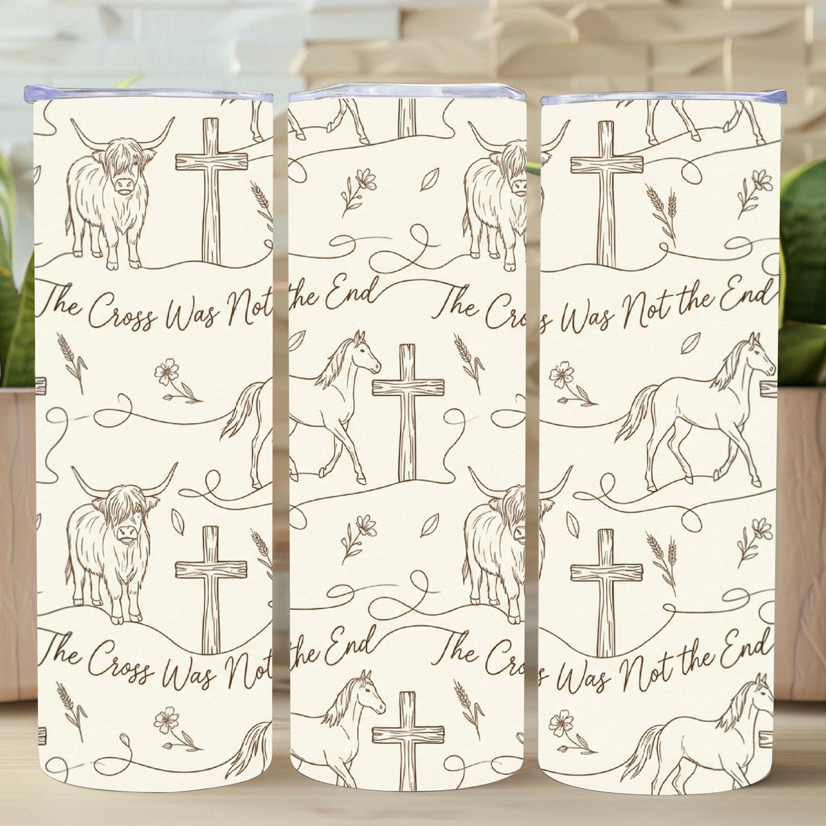 Three TUMBLERS with animal illustrations and cross designs on a wooden surface.