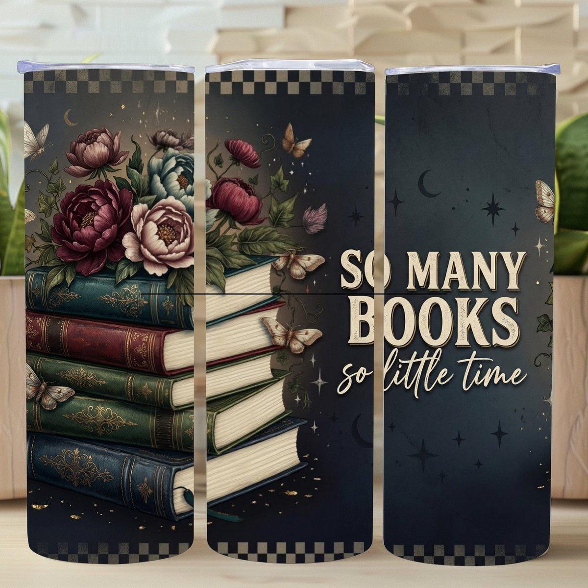 Three tumblers with book-themed designs and a motivational quote on a wooden surface with plants.