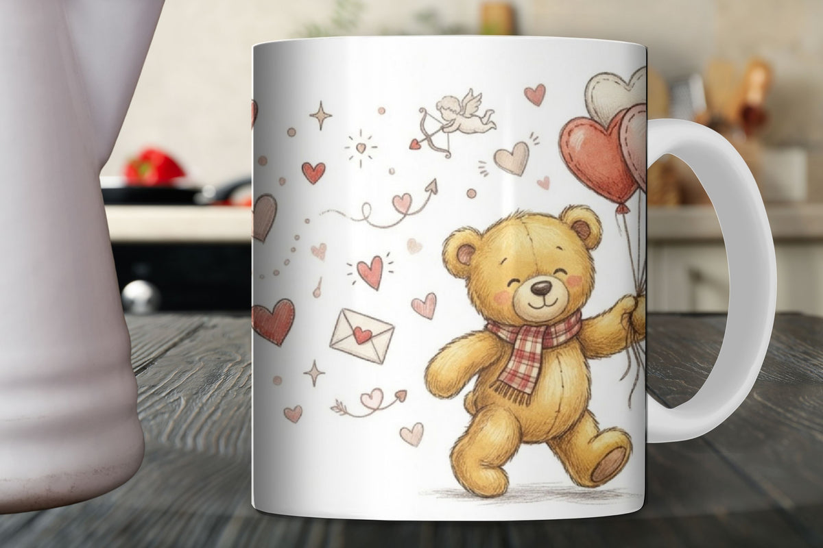 White mug with a teddy bear design featuring hearts and balloons on a wooden surface.