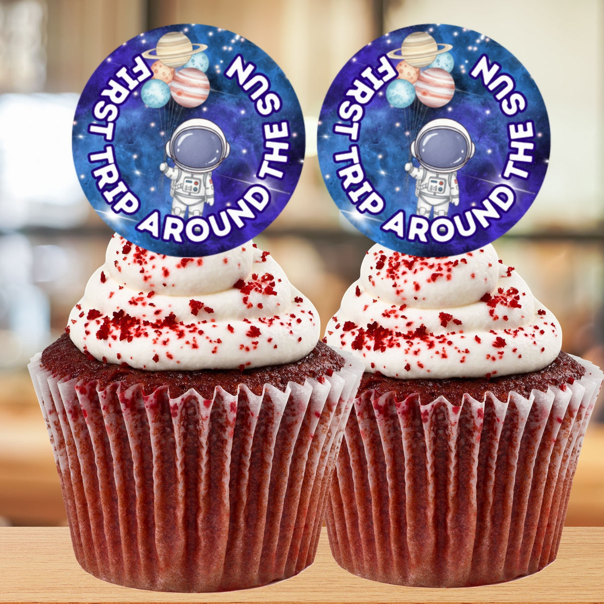 Two cupcakes with space-themed toppers on a blurred background