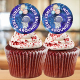 Two cupcakes with space-themed toppers on a blurred background