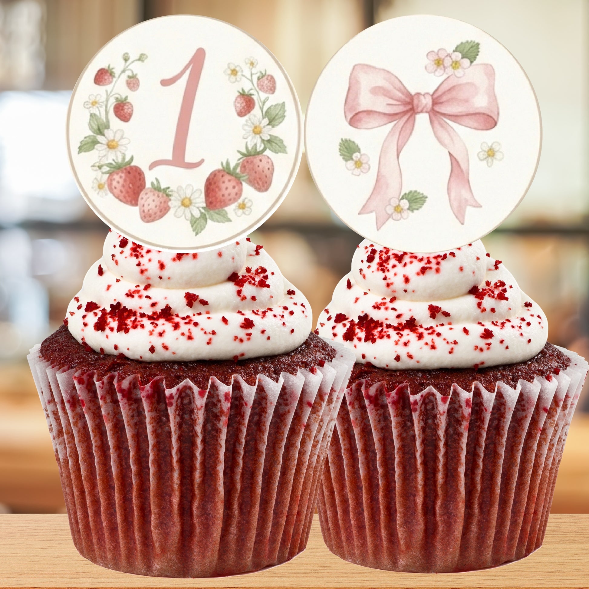Two red velvet cupcakes with decorative toppers on a blurred background