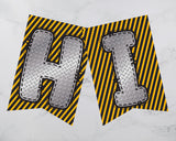 Decorative banner with 'HI' letters on a yellow and black striped background