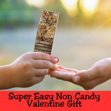 Two hands exchanging a decorative card with floral design against a blurred natural background.