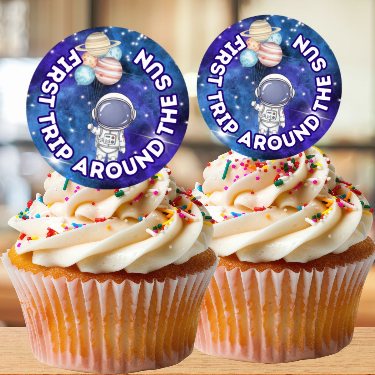 Two cupcakes with space-themed toppers on a wooden surface