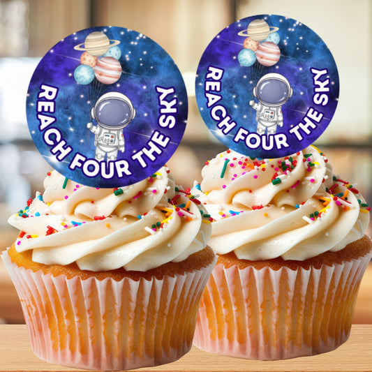 Two cupcakes with space-themed toppers and 'Reach Four the Sky' text on a blurred background.