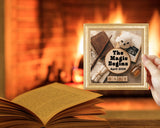 Framed baby announcement with teddy bear and books against a warm fireplace background
