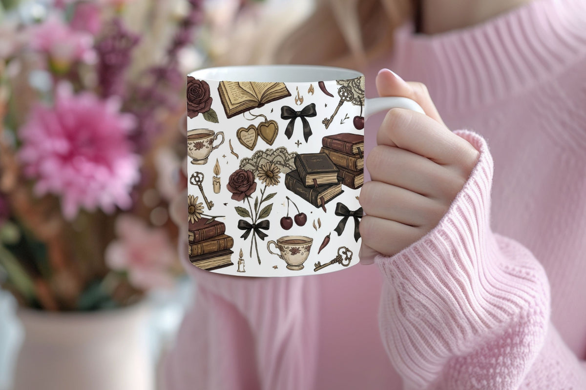 Person holding a mug with a decorative pattern of books, flowers, and ribbons.
