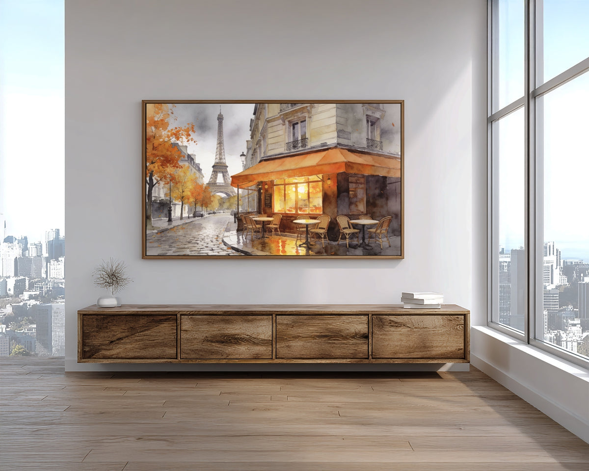 Framed artwork of a Parisian street scene above a wooden console table with a cityscape view through large windows.
