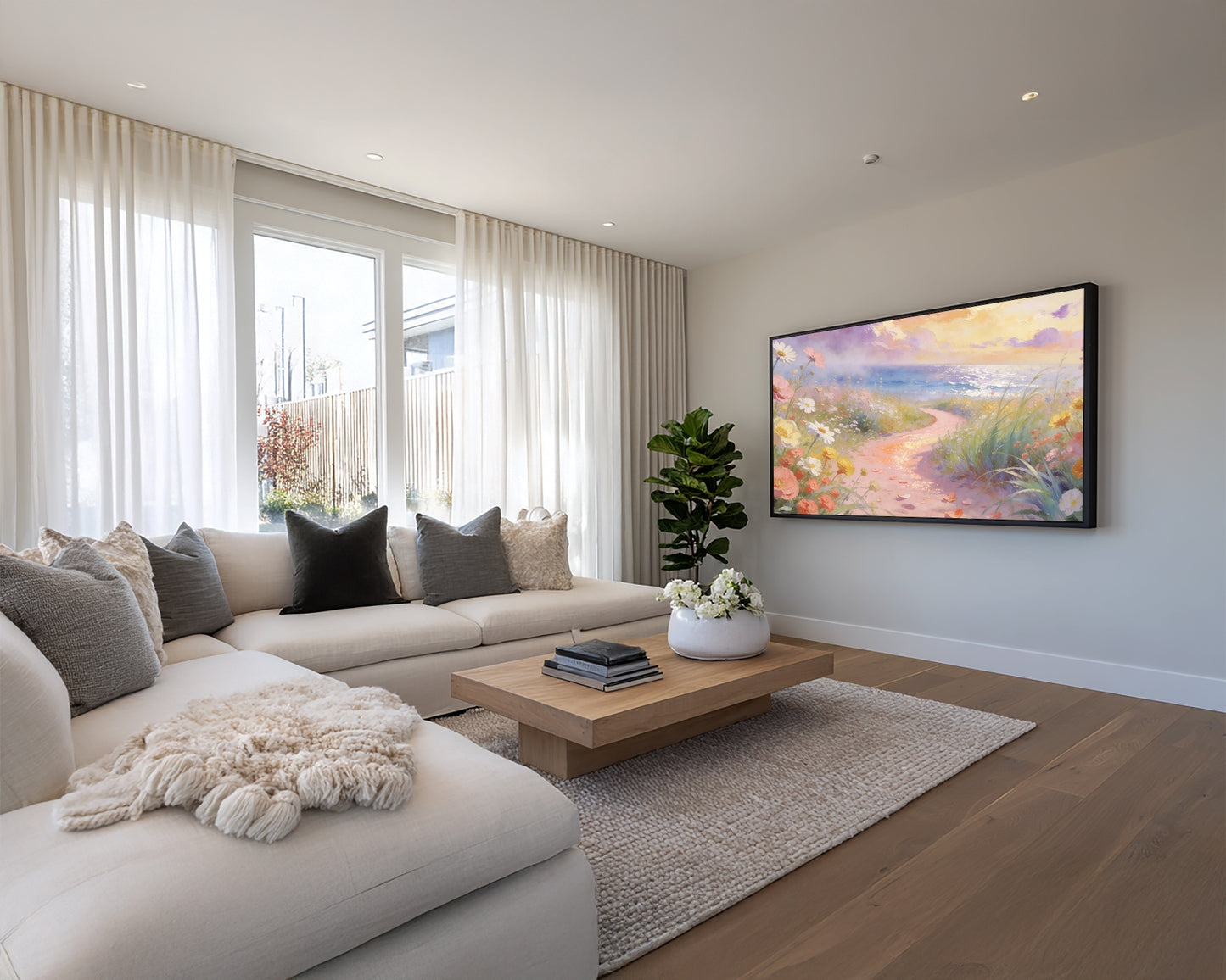 Modern living room with a sofa, coffee table, and wall-mounted TV displaying a scenic painting.