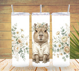 Three tumbler designs with a possum wearing a floral crown and surrounded by flowers on a wooden background.