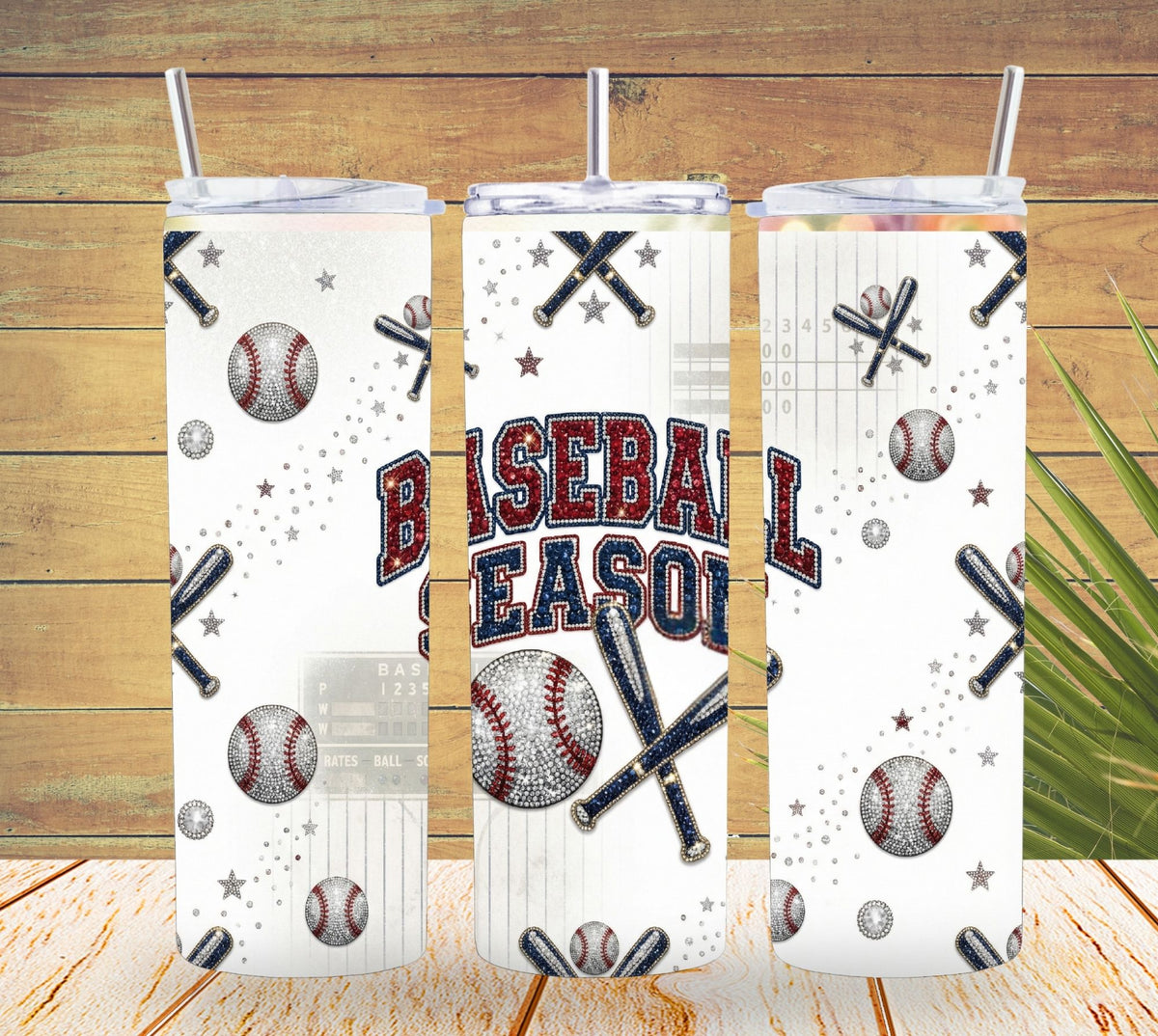 Three tumblers with baseball-themed designs on a wooden surface.