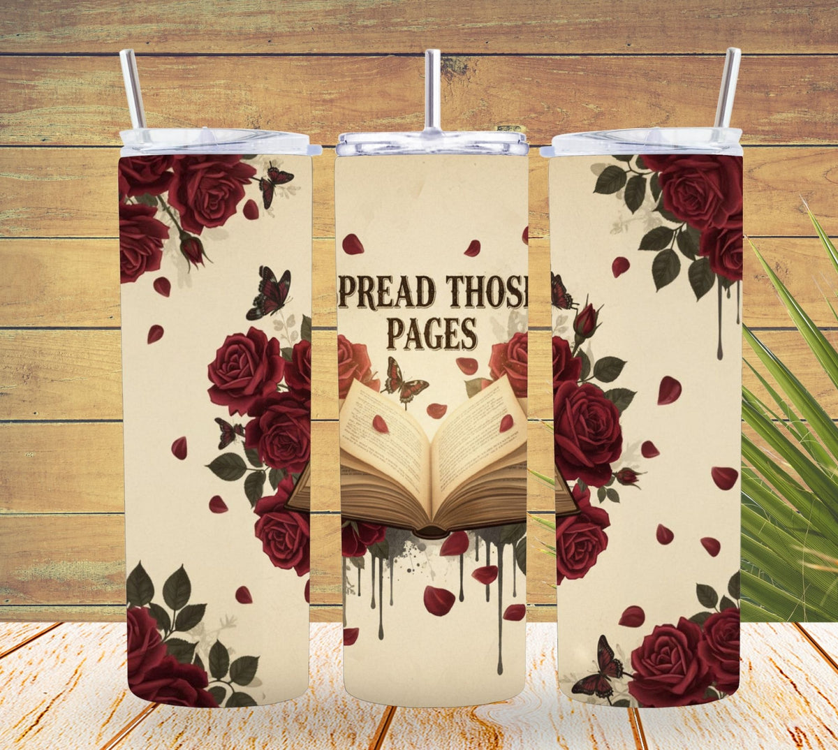 Three tumblers with floral and book design on a wooden surface
