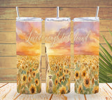 Three tumblers with a sunflower field and sunset design on a wooden background.