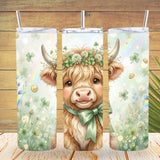 Tumbler with a cow design featuring flowers and a bow, on a wooden background.